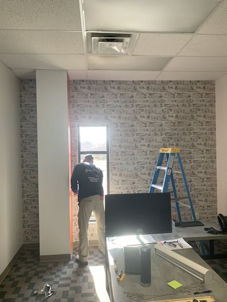 Traditions crew member installing wallpaper on a commercial job
